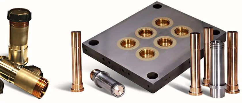 Custom plastic injection mold and progressive stamping die on a machining center with CNC-milled aluminum parts beside them