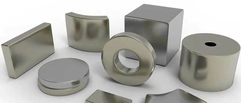 Neodymium arc magnets, countersunk blocks, and a Halbach array assembly graded by size on a factory inspection table