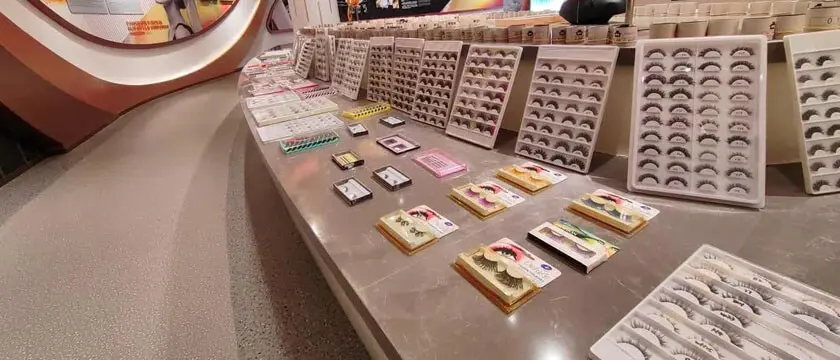 Rows of handmade false eyelash products and fiber materials at a factory workshop in Pingdu, Qingdao, China